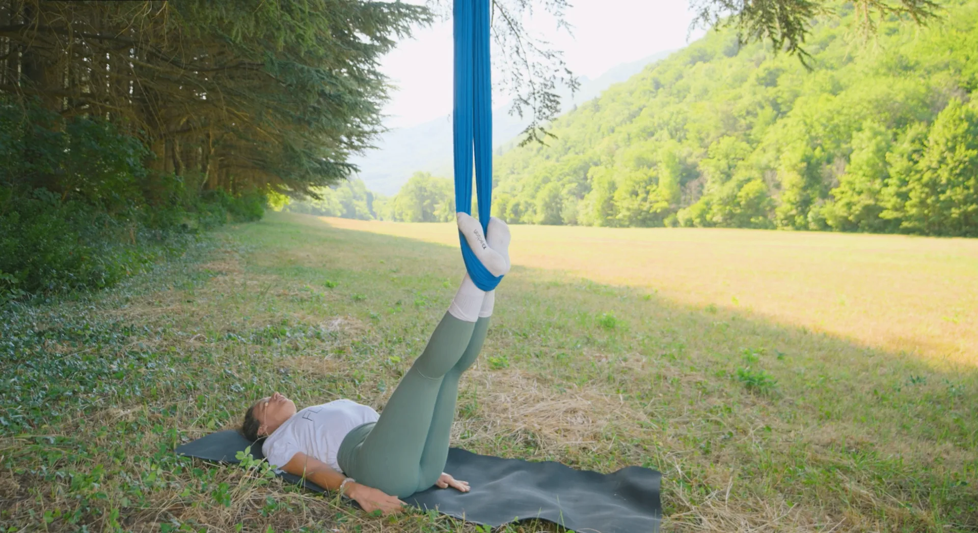 Étirement des jambes en hamac de yoga aérien Fly Yoga® en forêt